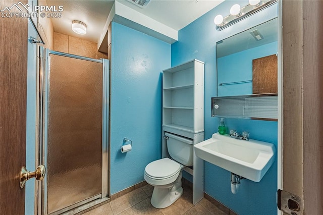 bathroom with toilet, sink, tile patterned floors, and walk in shower