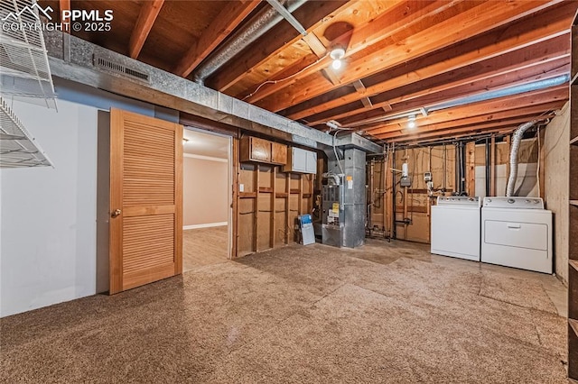 basement featuring heating unit and washer and dryer