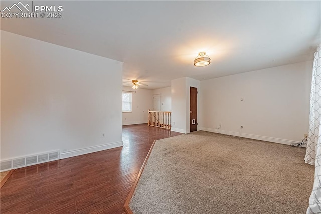 unfurnished living room with dark wood-type flooring and ceiling fan