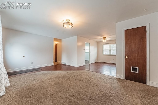 empty room with dark carpet and ceiling fan