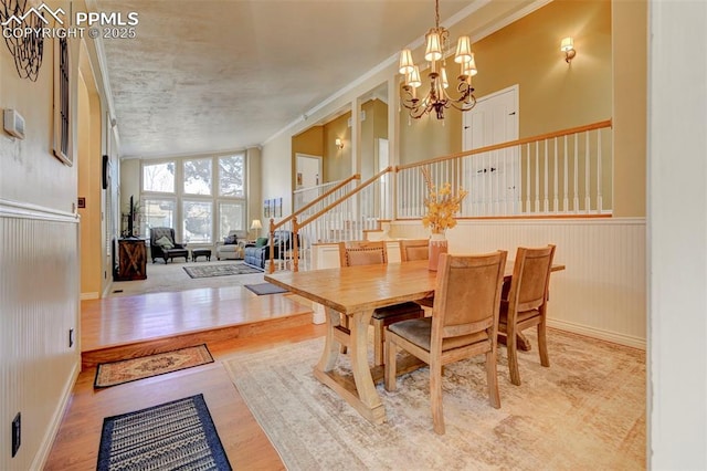 dining area featuring crown molding, a notable chandelier, and light wood-type flooring