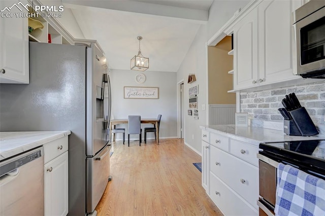 kitchen featuring pendant lighting, white cabinetry, stainless steel appliances, light stone counters, and light wood-type flooring