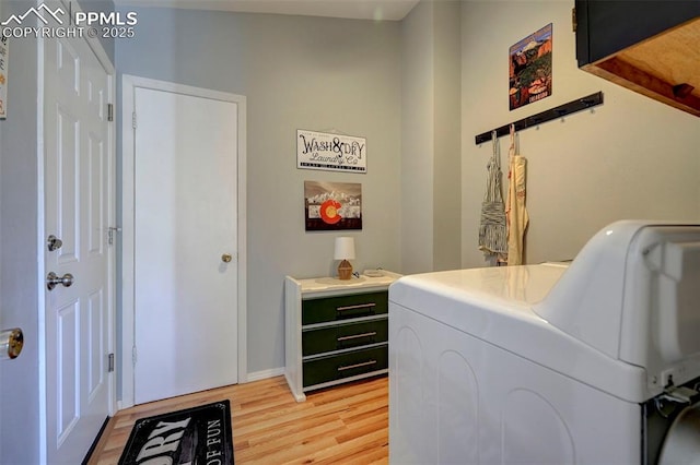 laundry area with separate washer and dryer and light hardwood / wood-style floors