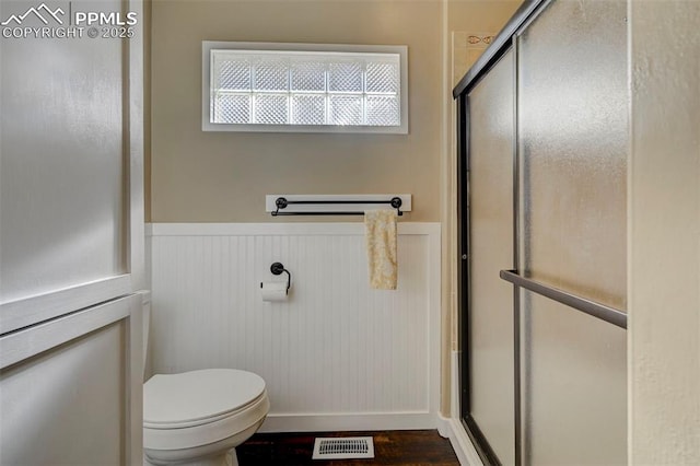 bathroom featuring walk in shower and toilet