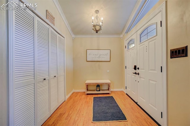 entrance foyer with ornamental molding, a chandelier, and light hardwood / wood-style flooring