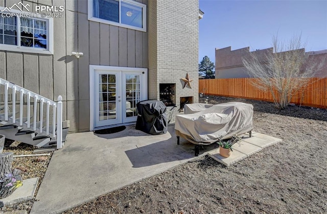 view of patio with an outdoor brick fireplace, area for grilling, and french doors