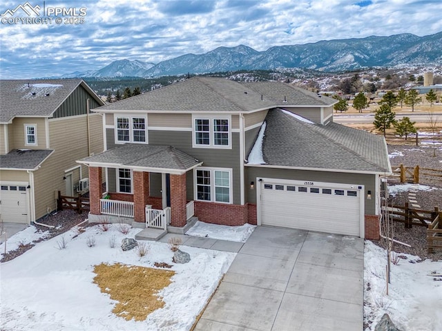 front of property featuring a mountain view, a garage, and covered porch