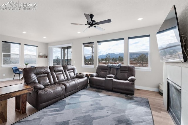 living room featuring light hardwood / wood-style flooring and ceiling fan