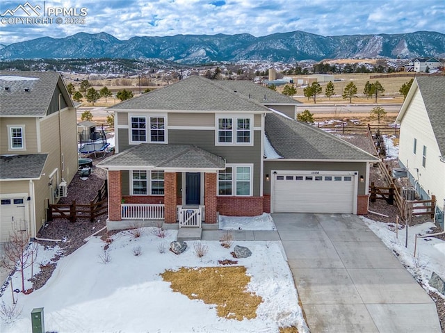 view of front of property featuring a porch, a mountain view, and a garage