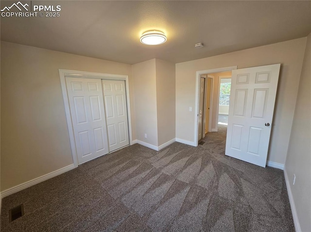 unfurnished bedroom featuring a closet and dark colored carpet