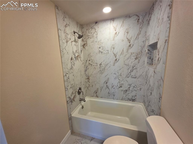 bathroom featuring toilet and tiled shower / bath