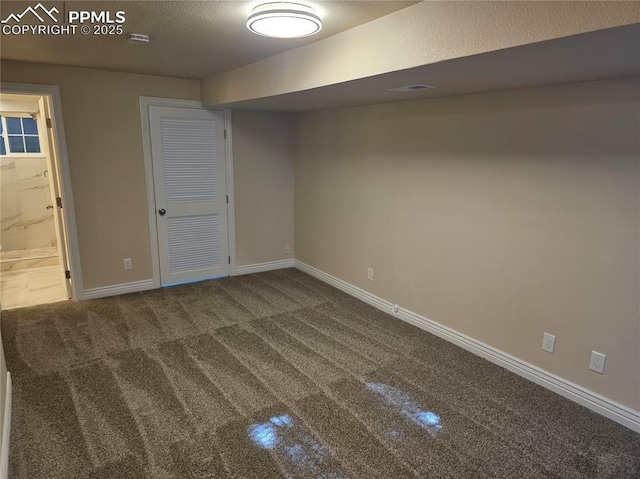 basement with dark carpet and a textured ceiling