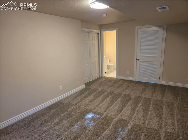 interior space featuring ensuite bathroom and carpet flooring