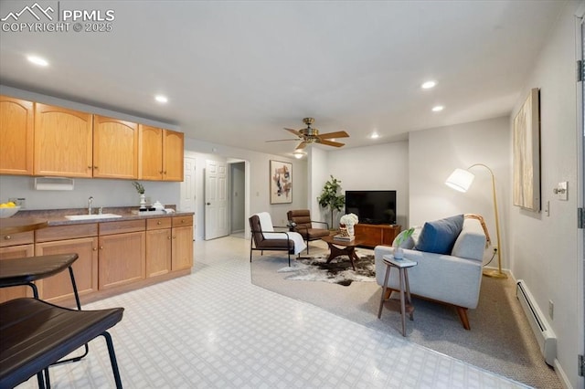 kitchen with recessed lighting, a baseboard radiator, light brown cabinets, and a sink