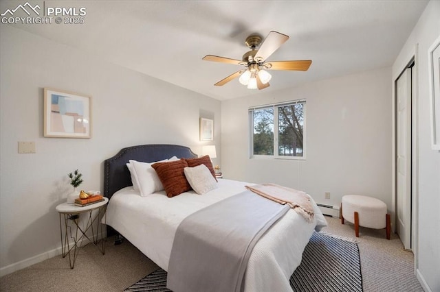 bedroom with baseboards, ceiling fan, a closet, light carpet, and a baseboard heating unit