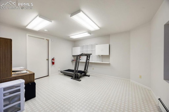 exercise area featuring baseboards, baseboard heating, and carpet floors