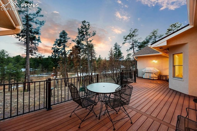 deck at dusk with area for grilling and outdoor dining area