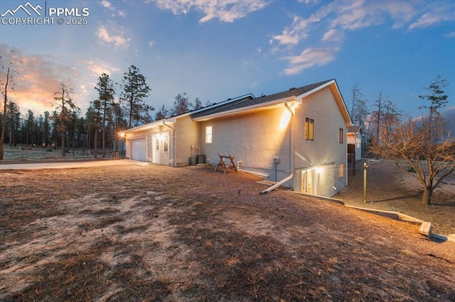 view of property exterior with stucco siding, concrete driveway, and a garage