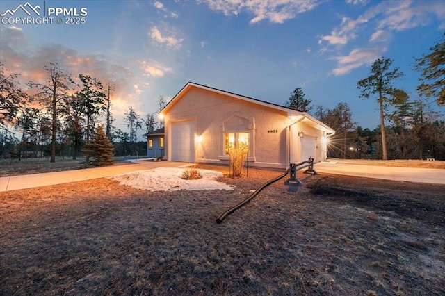 view of front of property with stucco siding, driveway, and a garage