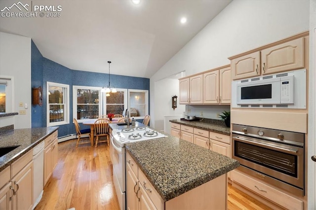 kitchen with white appliances, vaulted ceiling, light wood-style floors, and light brown cabinetry