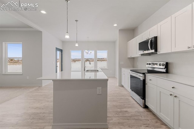 kitchen with sink, white cabinetry, hanging light fixtures, an island with sink, and electric stove