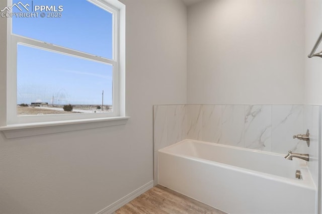 bathroom with a bathing tub and wood-type flooring