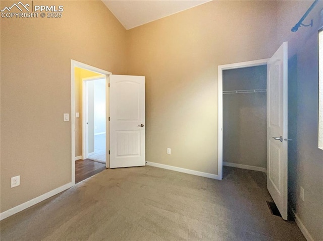 unfurnished bedroom with vaulted ceiling, carpet floors, and a closet