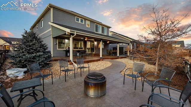 back house at dusk with a patio and an outdoor fire pit