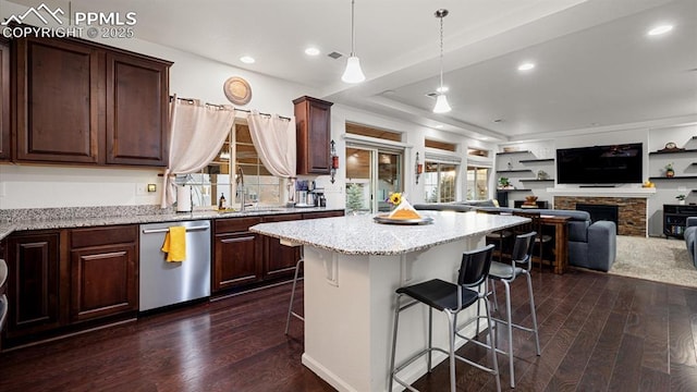 kitchen featuring sink, hanging light fixtures, stainless steel dishwasher, dark hardwood / wood-style flooring, and a kitchen island