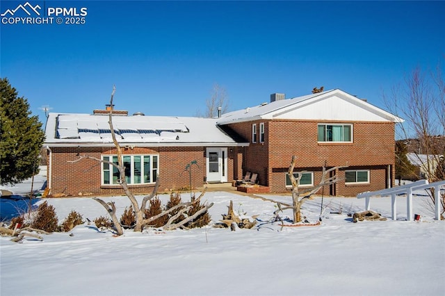 101 Welton Ave, Walsenburg, CO 81089 - snow covered back of property featuring brick siding, a chimney, and central AC unit