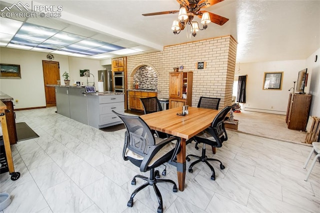 office space featuring ceiling fan, brick wall, and baseboard heating