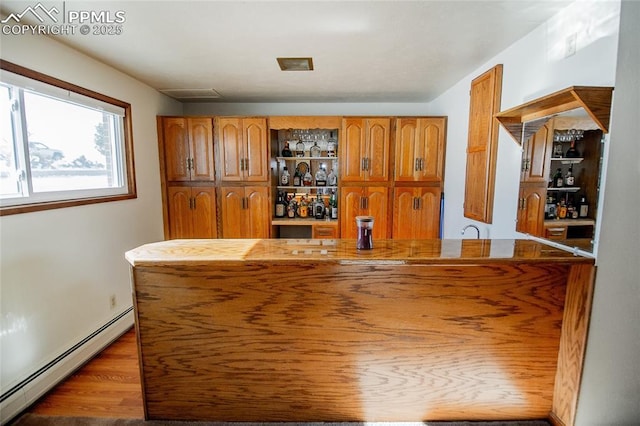 bar with dark hardwood / wood-style flooring and a baseboard heating unit