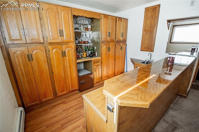 kitchen featuring sink, light wood-type flooring, and baseboard heating