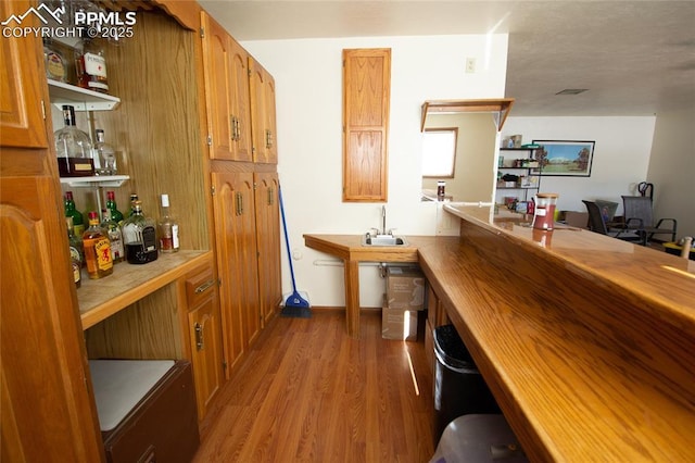 bar with sink and light hardwood / wood-style flooring