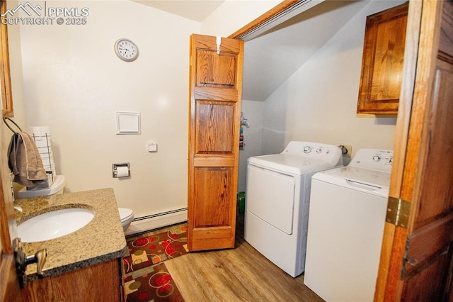 washroom with independent washer and dryer, light hardwood / wood-style floors, sink, and a baseboard heating unit