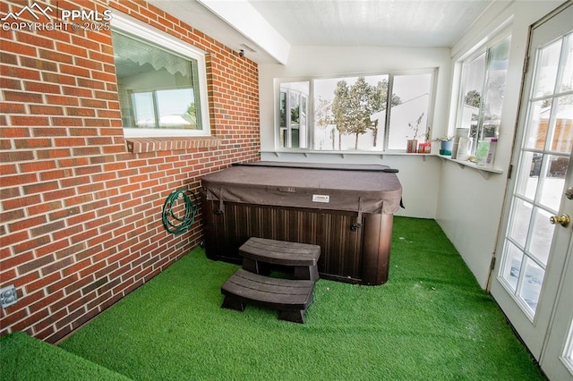 sunroom with vaulted ceiling and a hot tub