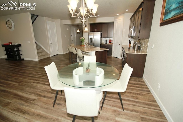 dining space with dark hardwood / wood-style flooring and a notable chandelier