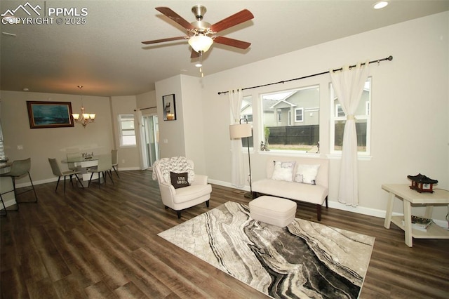 living room featuring dark hardwood / wood-style flooring and ceiling fan with notable chandelier