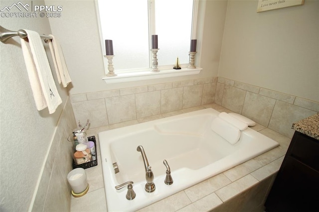 bathroom featuring vanity and tiled tub