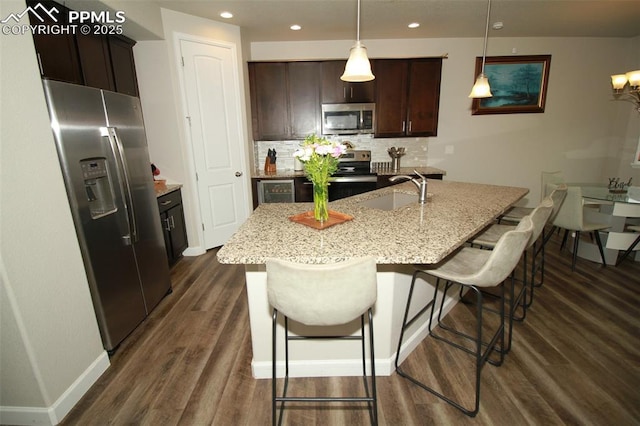 kitchen with sink, hanging light fixtures, an island with sink, and appliances with stainless steel finishes