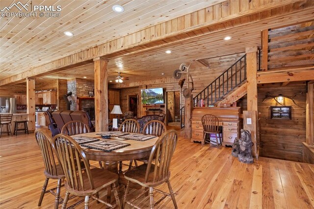 dining room with wooden walls, wooden ceiling, light hardwood / wood-style floors, and ceiling fan