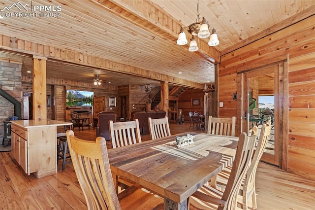 dining space featuring wood ceiling, wood walls, light wood-type flooring, and a wood stove