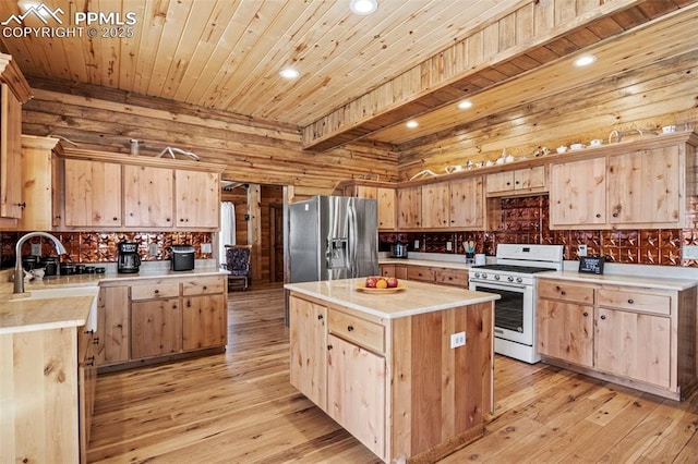 kitchen featuring stainless steel refrigerator with ice dispenser, light brown cabinetry, white stove, a center island, and light wood-type flooring