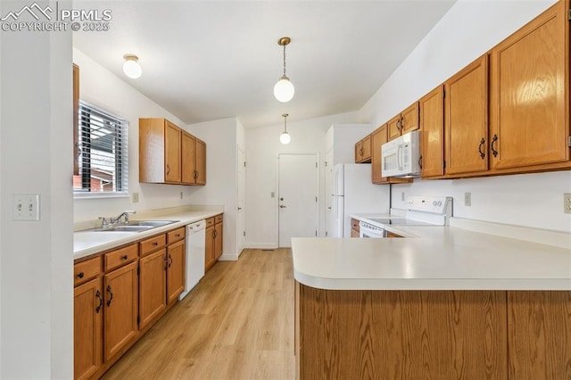 kitchen with pendant lighting, sink, white appliances, kitchen peninsula, and light wood-type flooring