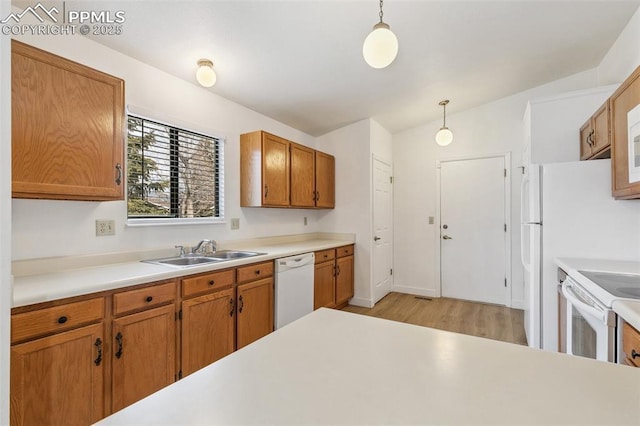 kitchen with white appliances, lofted ceiling, decorative light fixtures, and sink