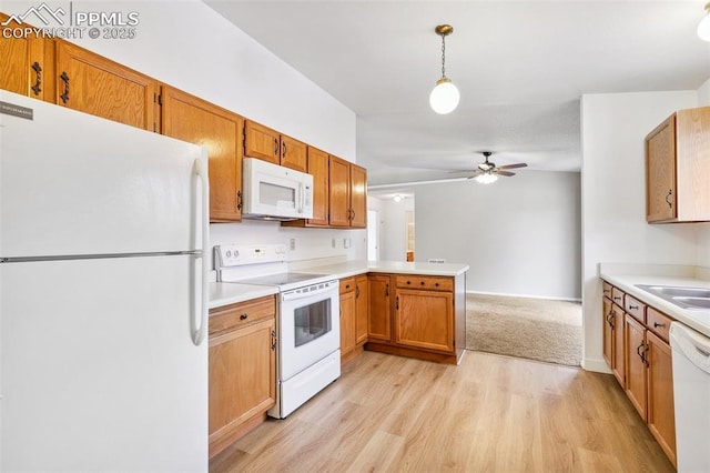 kitchen with kitchen peninsula, hanging light fixtures, ceiling fan, light hardwood / wood-style floors, and white appliances