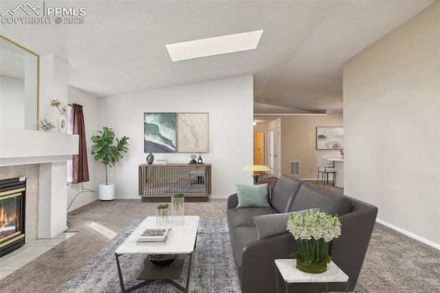 living room featuring a tiled fireplace, light colored carpet, and lofted ceiling