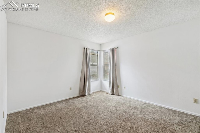 empty room with a textured ceiling and carpet flooring