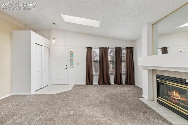 entrance foyer featuring vaulted ceiling, light carpet, a textured ceiling, and a fireplace