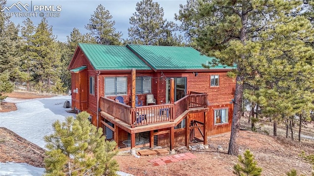 back of property featuring a standing seam roof, metal roof, and a deck